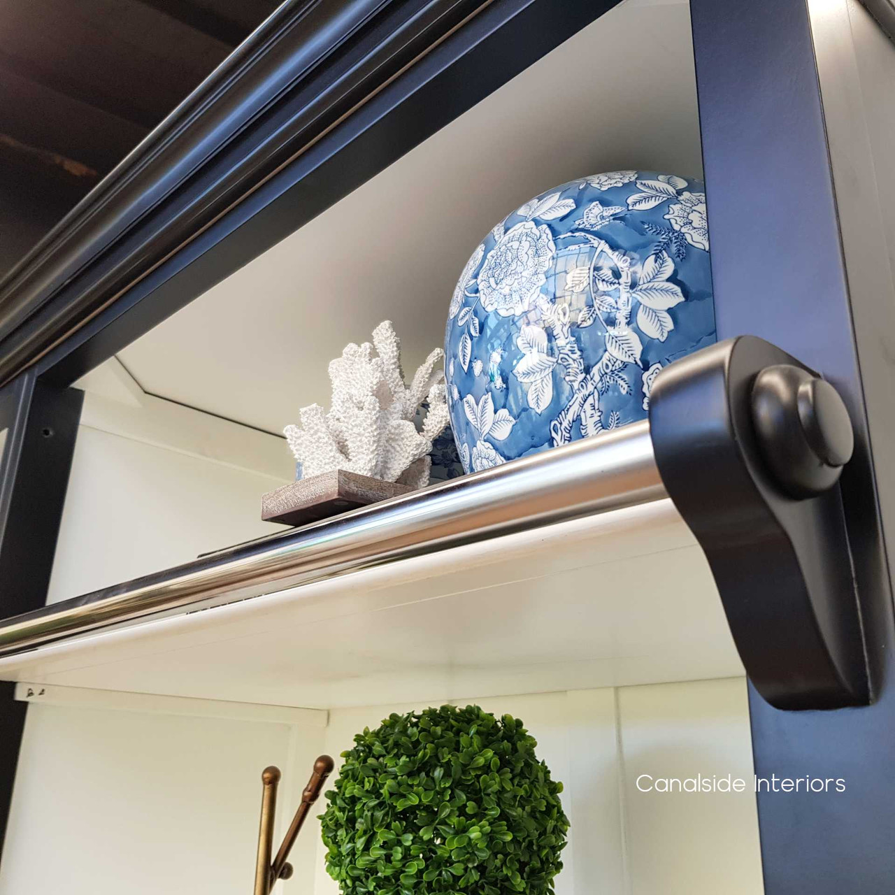 A coastal retreat's dream, this black and white bookcase from the Grange collection offers a chic contrast in your dining room