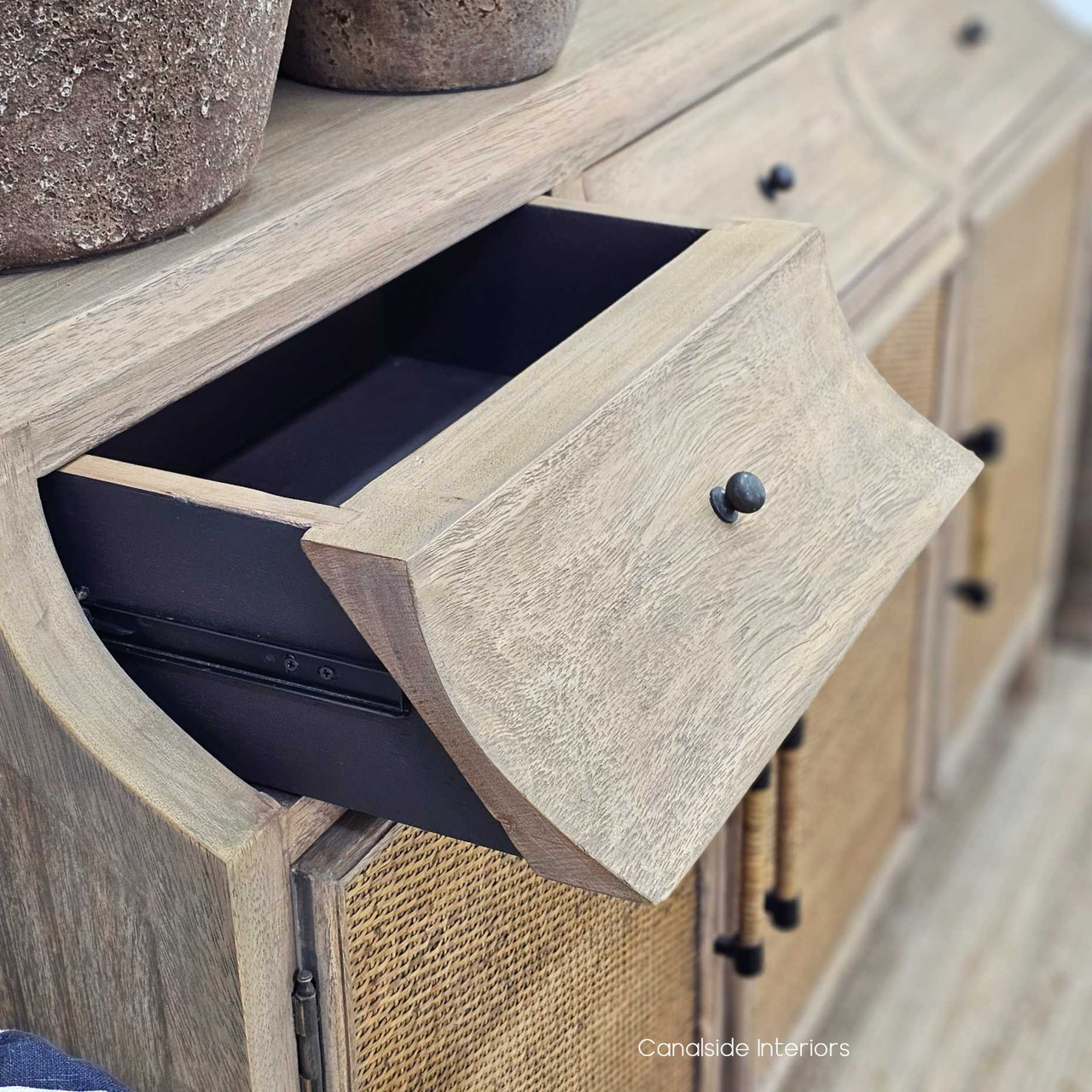 Angled front-left view with the top drawer open, showcasing the smooth interior, metal runner and curved drawer front detail.