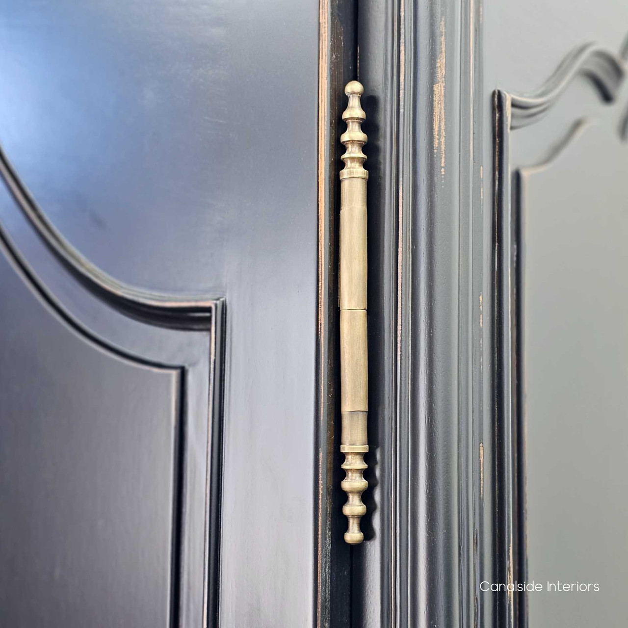 Close-up of the aged brass hinge, showcasing the antique-style hardware and contrasting beautifully against the distressed black finish.