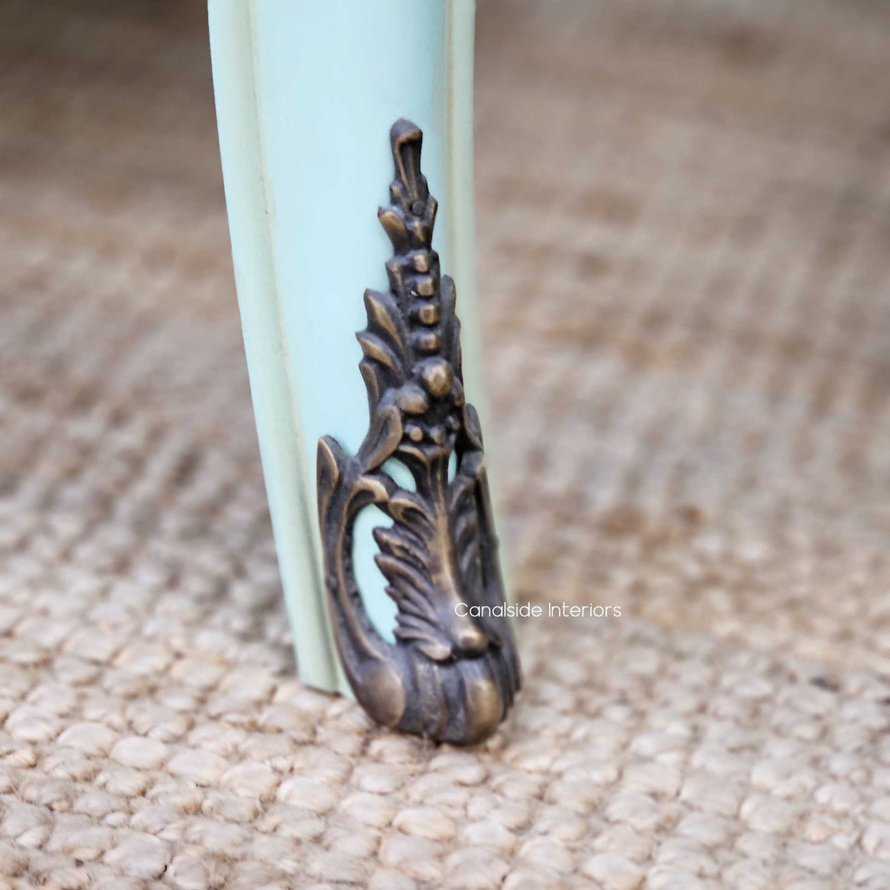 Side angle focusing on the flared leg design, with visible distressing along the base and aged brass hardware