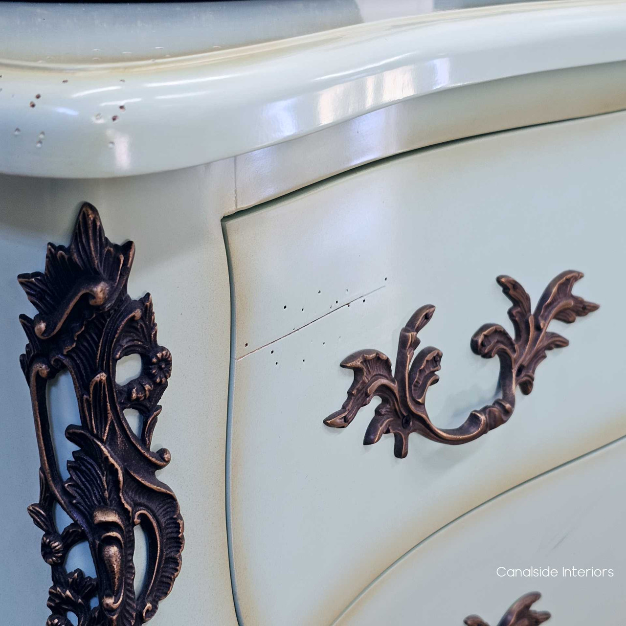Close-up of the carved side bracket detail, featuring patina contrast and elegant lines.