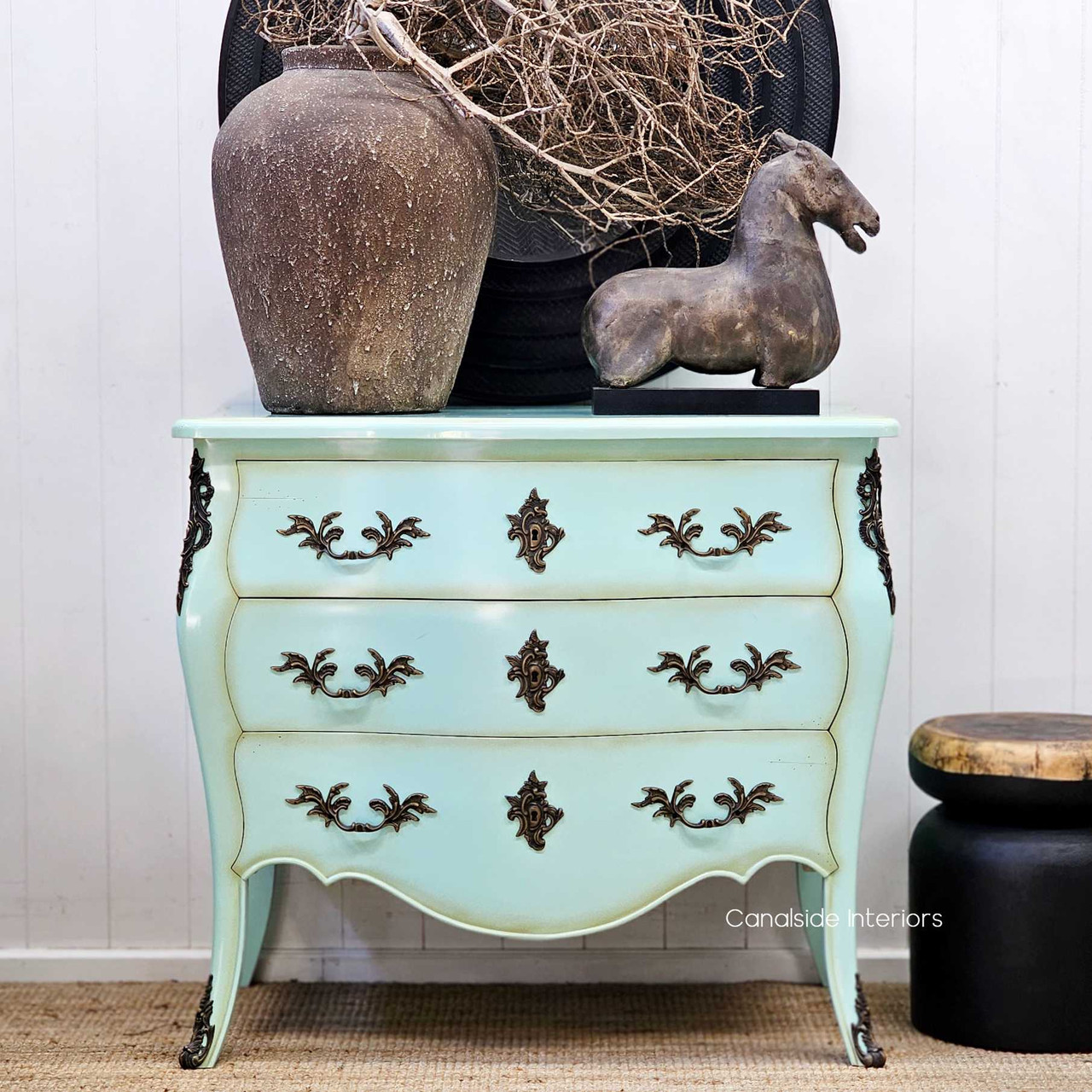 Shot of the chest styled in a hallway with vintage décor, adding bold colour and personality.