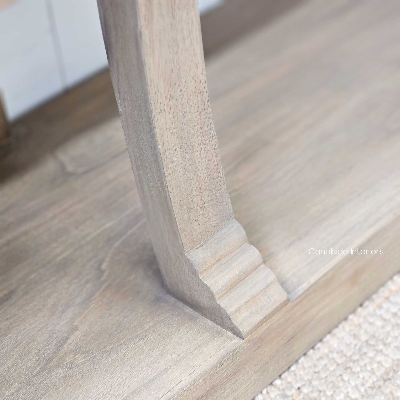 Leg detail from a low angle, capturing the solid stance and artisan flair.