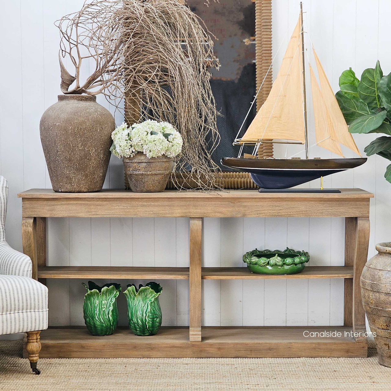 Console styled with a mirror above, creating a focal point in a transitional space.