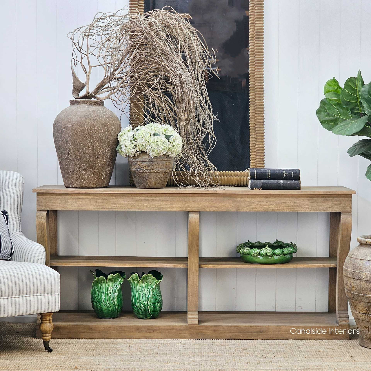 Console styled with vintage books and stone vessels, perfect for timeless interiors.