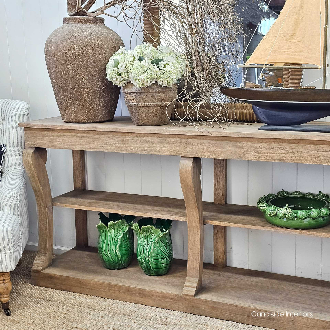 Decorative green ceramics on the bottom shelf, adding colour contrast and charm.