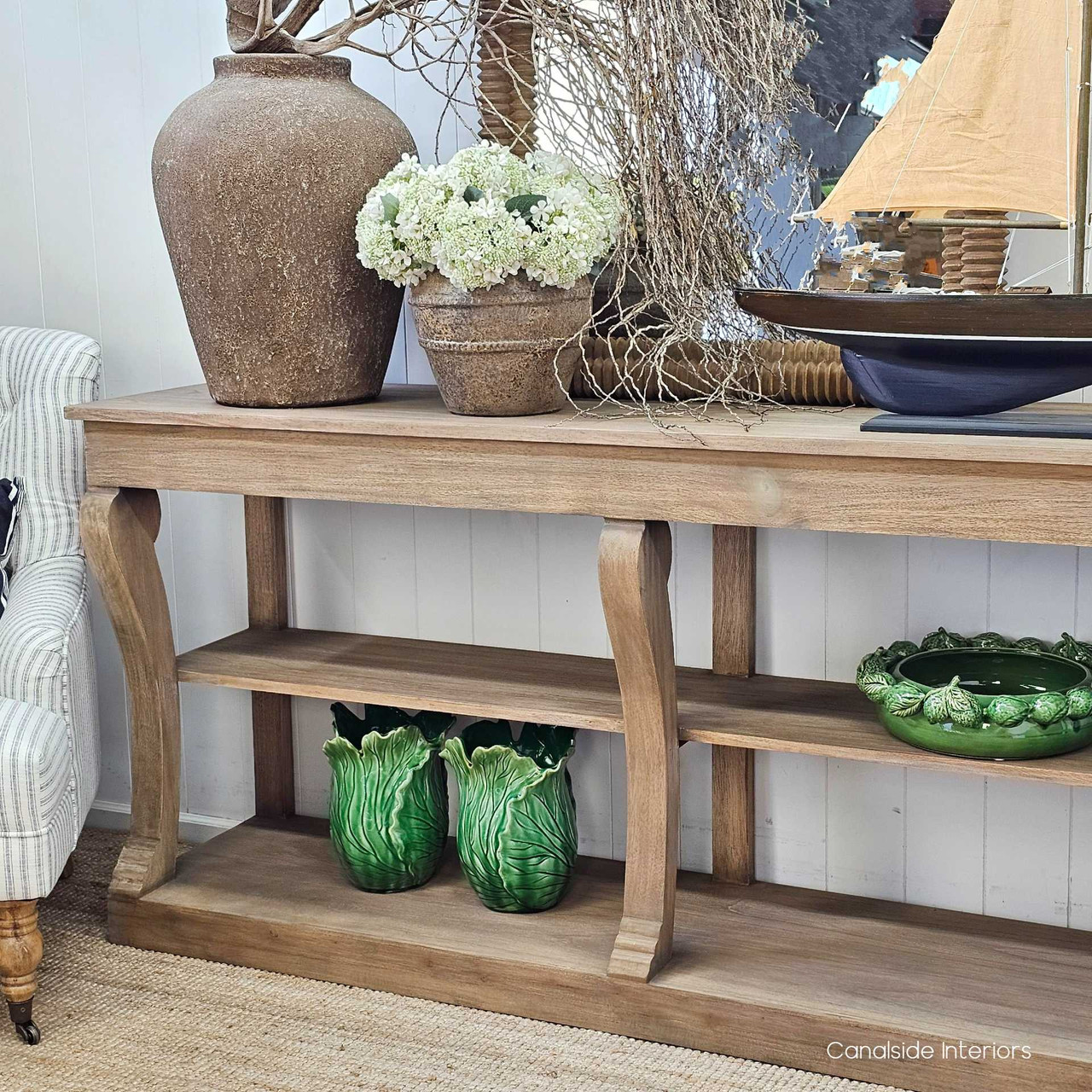 Bottom shelf with sculptural decor and baskets, demonstrating functional styling.