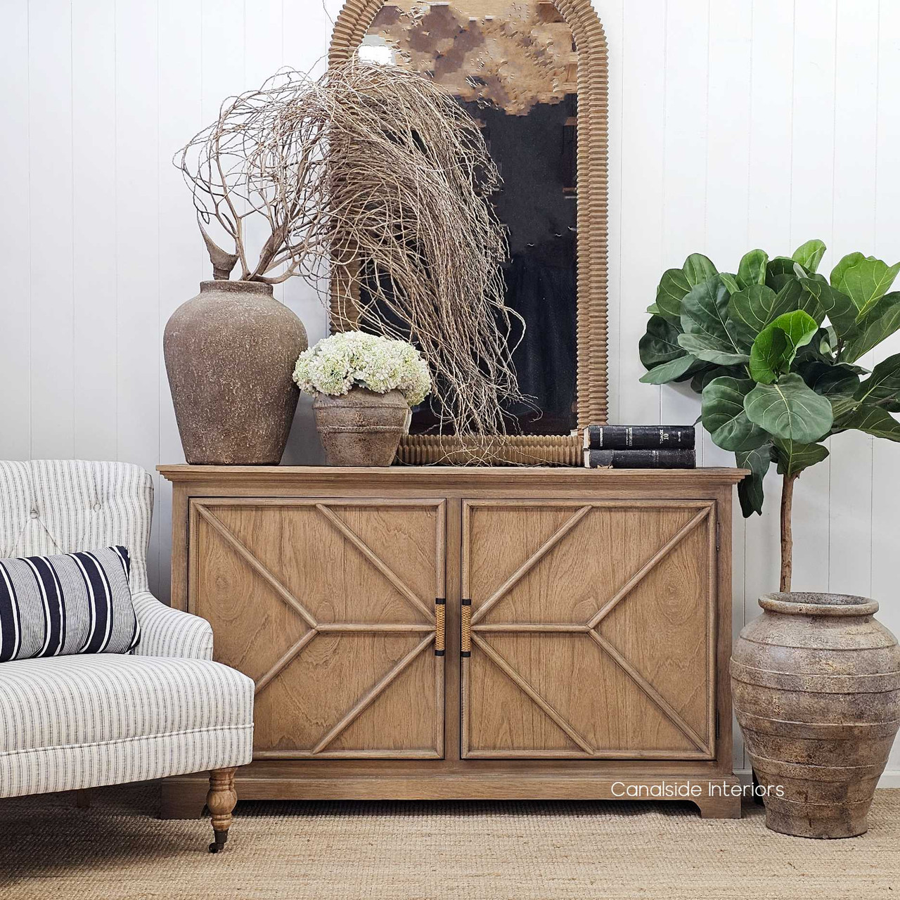 Full vignette with mirror, vases, and books styled on top of the sideboard.