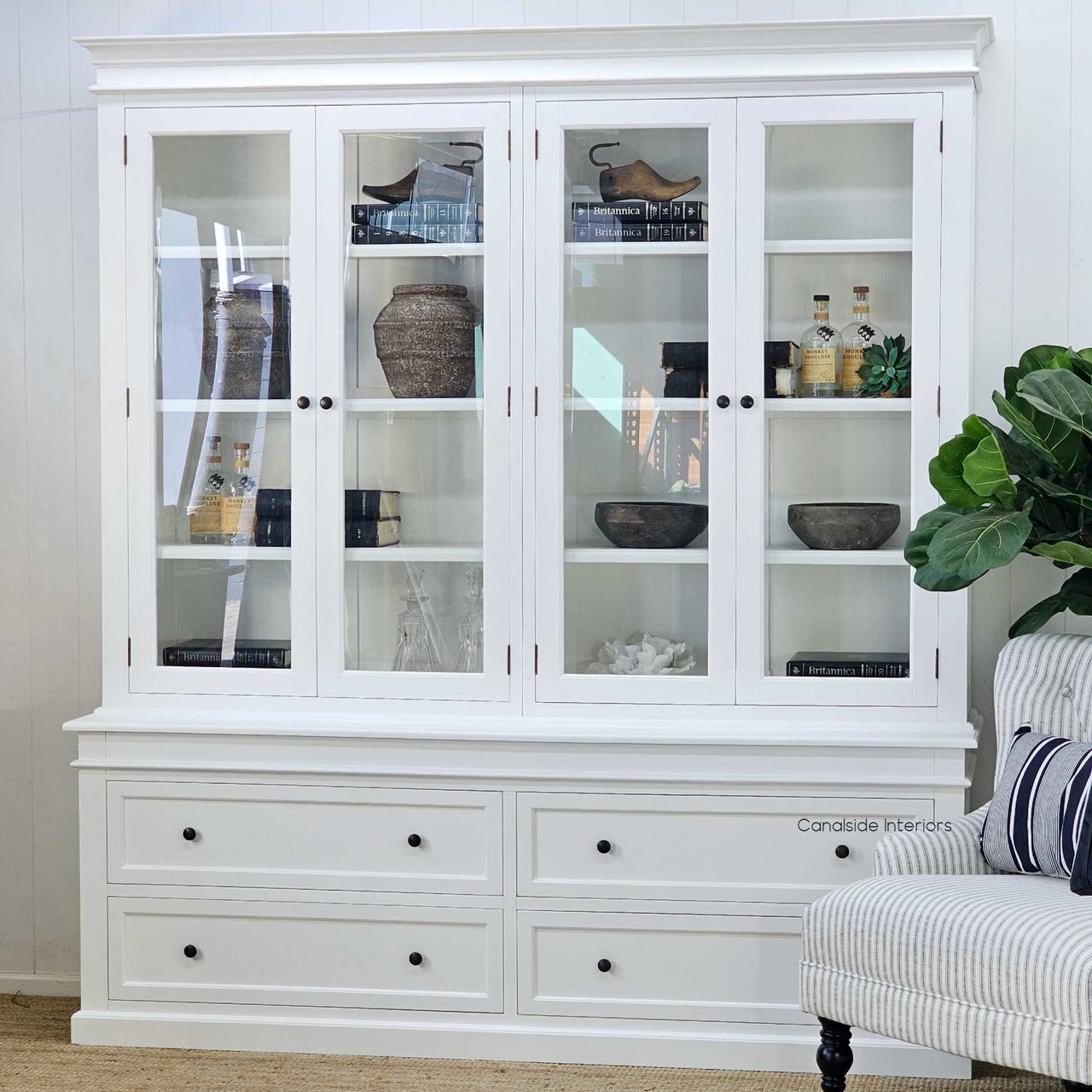 Shelving arranged with coral, books, and black-and-white accents for coastal styling.
