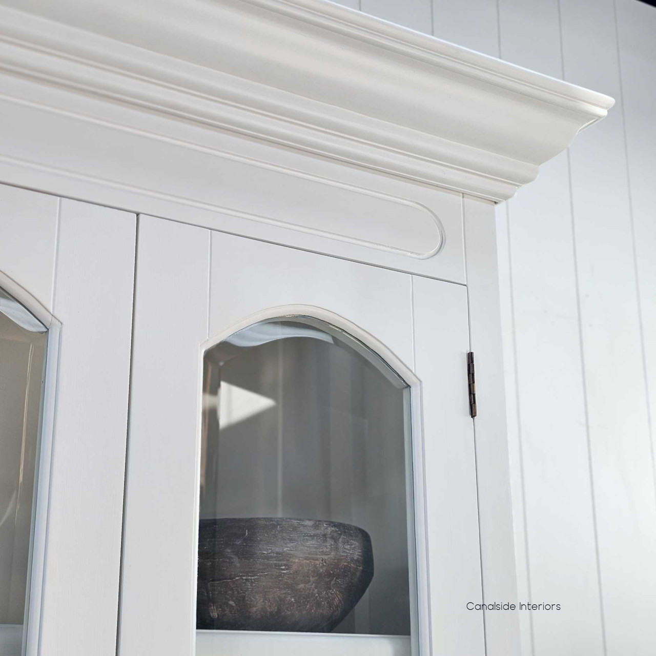 Close-up of the arched moulding on a bevelled glass-panel door, highlighting craftsmanship and design detail.