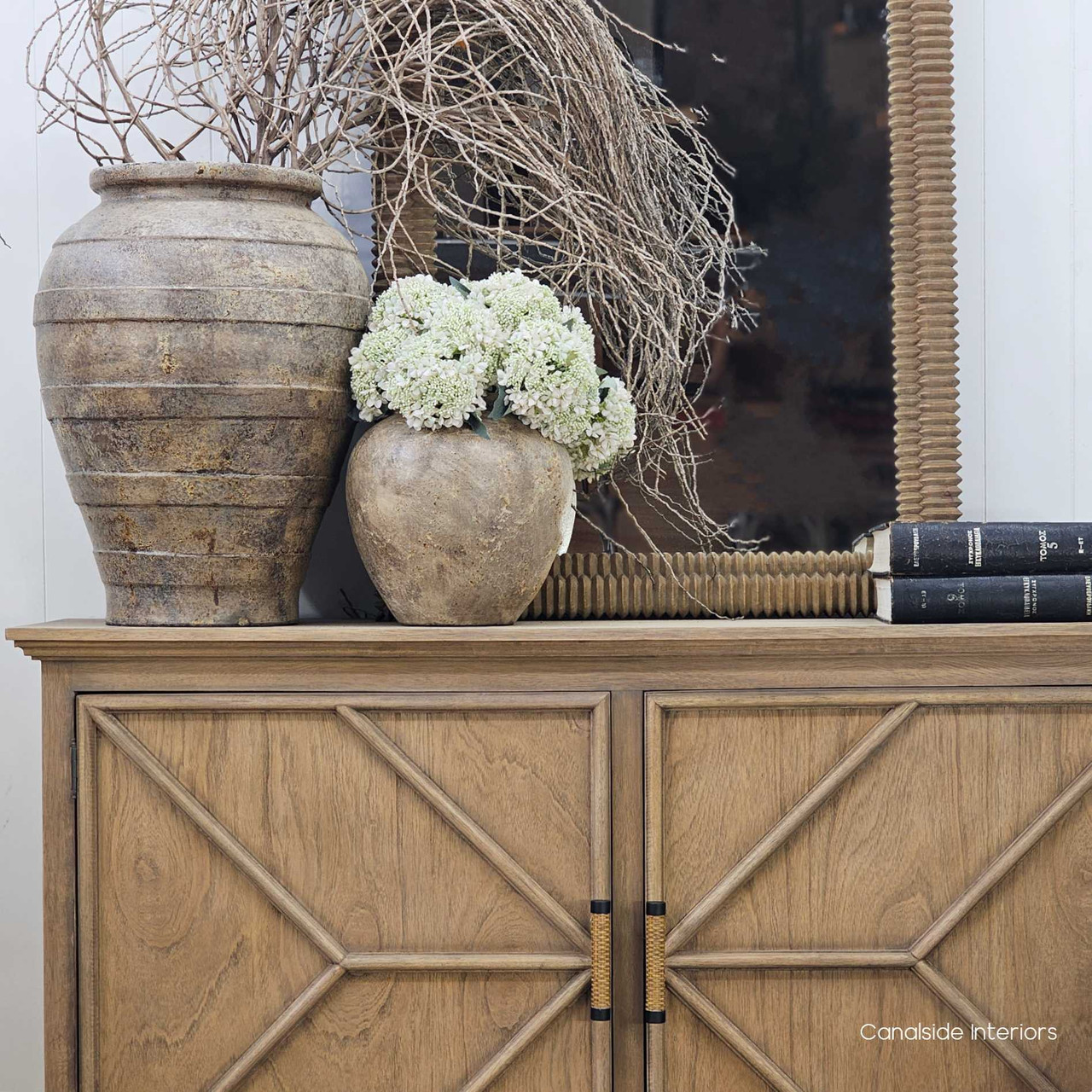 Noema vessel placed beside other clay pots, demonstrating its unique finish and sculptural presence.