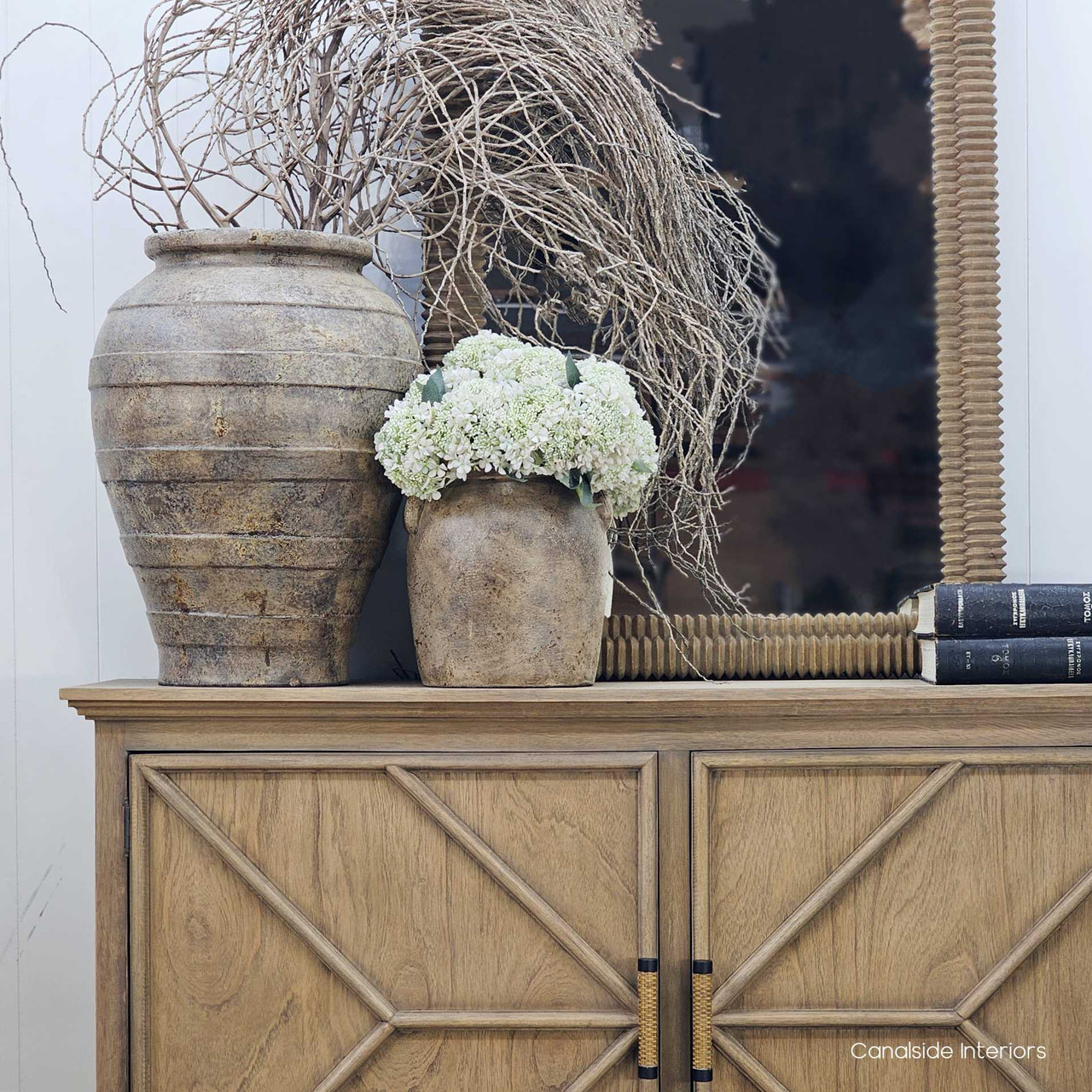 Sekar vessel grouped in a styled vignette, layered with other earthenware pieces on a timber console.