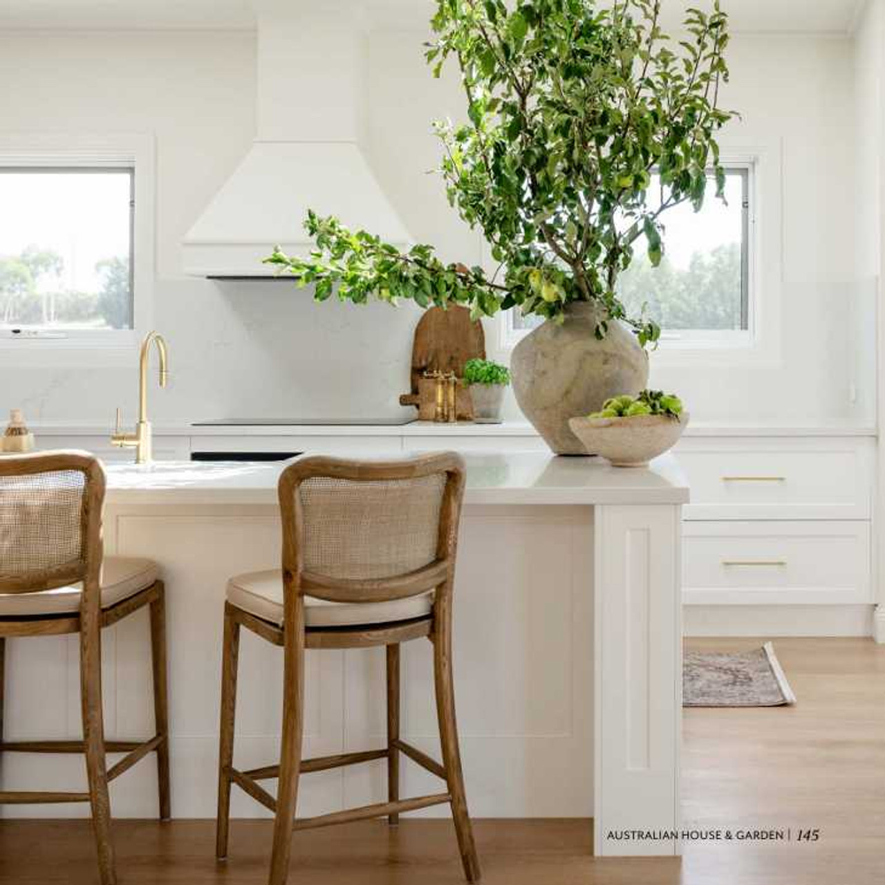 Curved-back Noda stools bringing warmth to the magazine-featured kitchen.