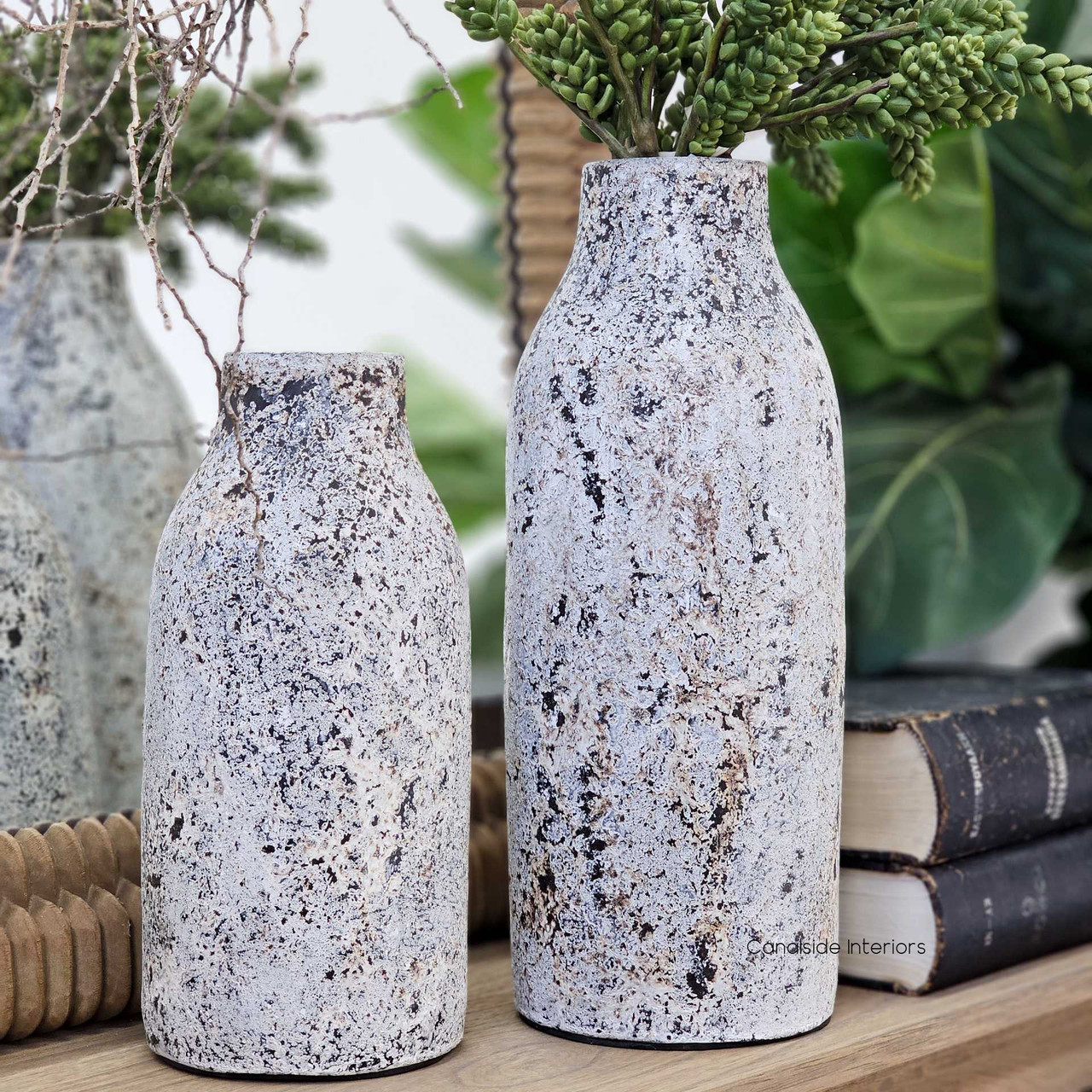 Side view of both small and tall Lani vessels displayed with greenery, styled on a timber shelf with natural décor and vintage books.