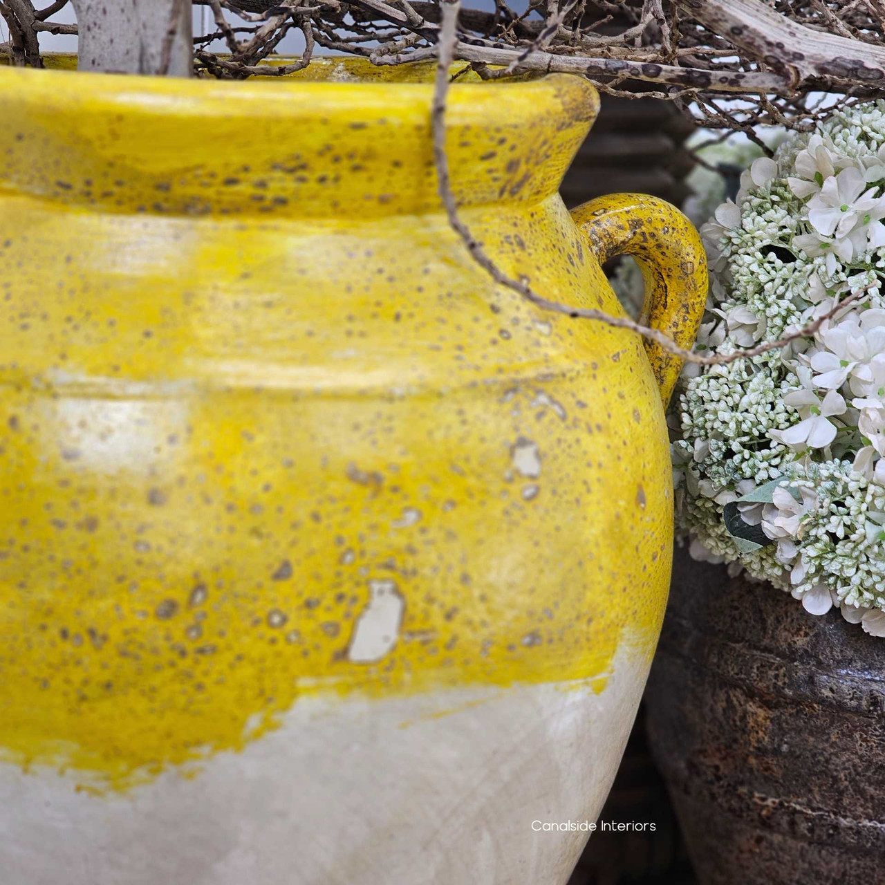 Close-up of the aged yellow paint finish and handle detail, highlighting the speckled surface and aged patina.