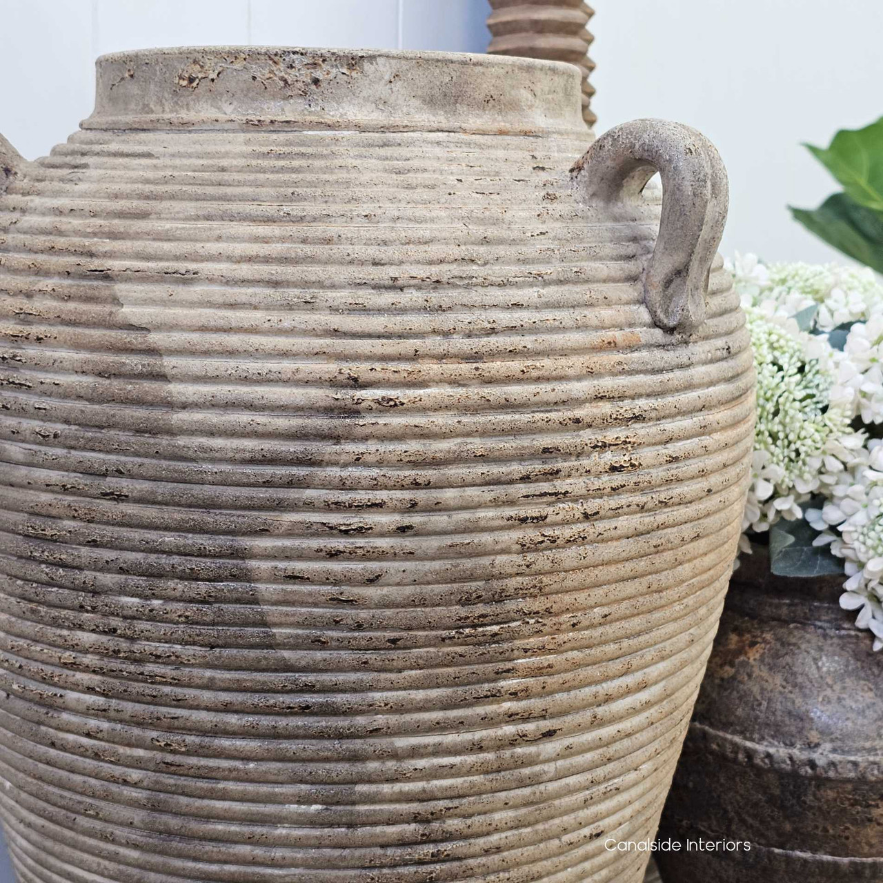 Angle highlighting the textured terracotta surface, with mottled clay tones and softly weathered character.