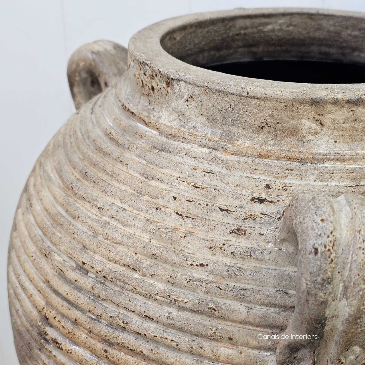 Close-up of the surface detailing, highlighting the horizontal ridges and aged earthenware finish.