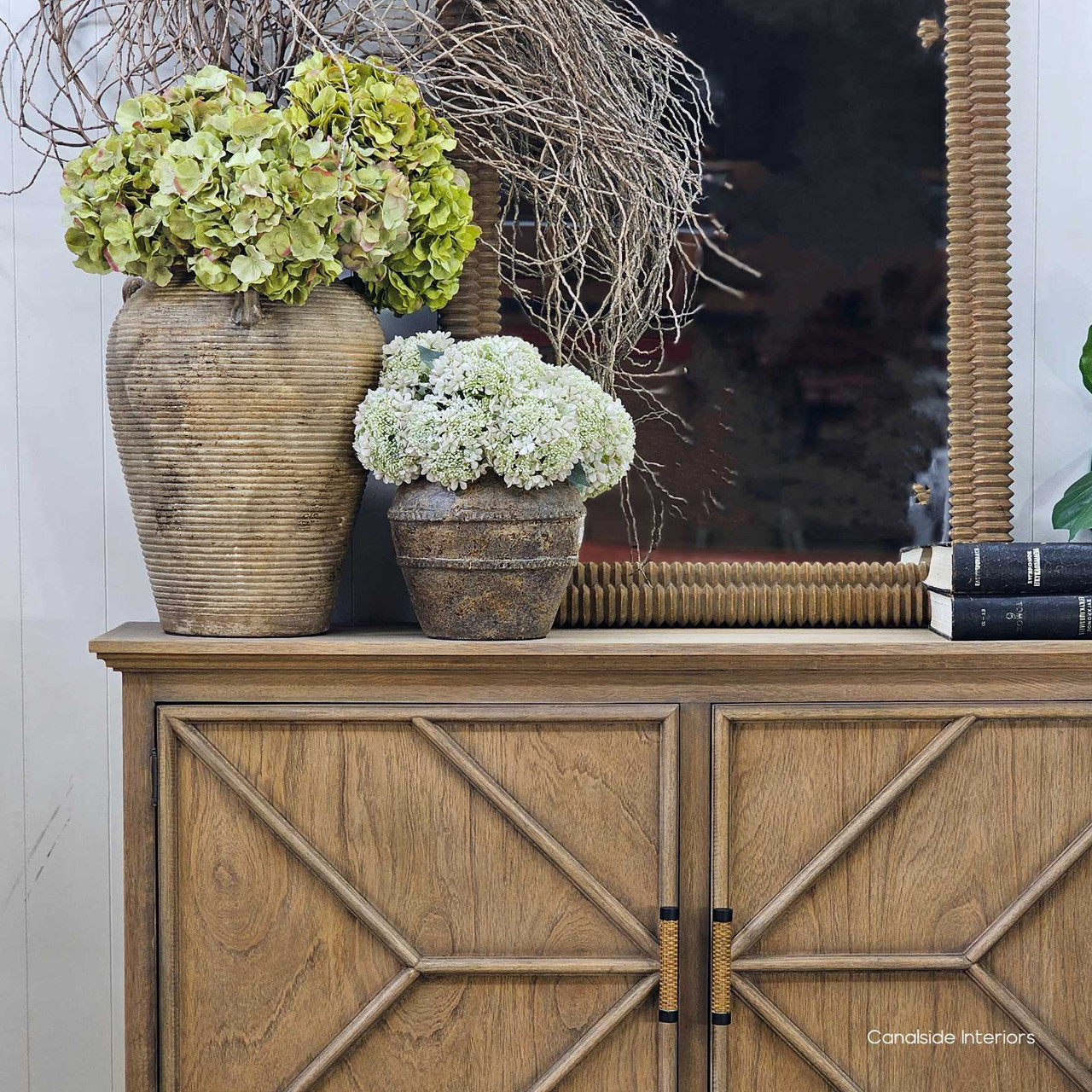 Lirien styled with layered pottery on a console, showcasing its ability to anchor a grouped vignette with visual weight.