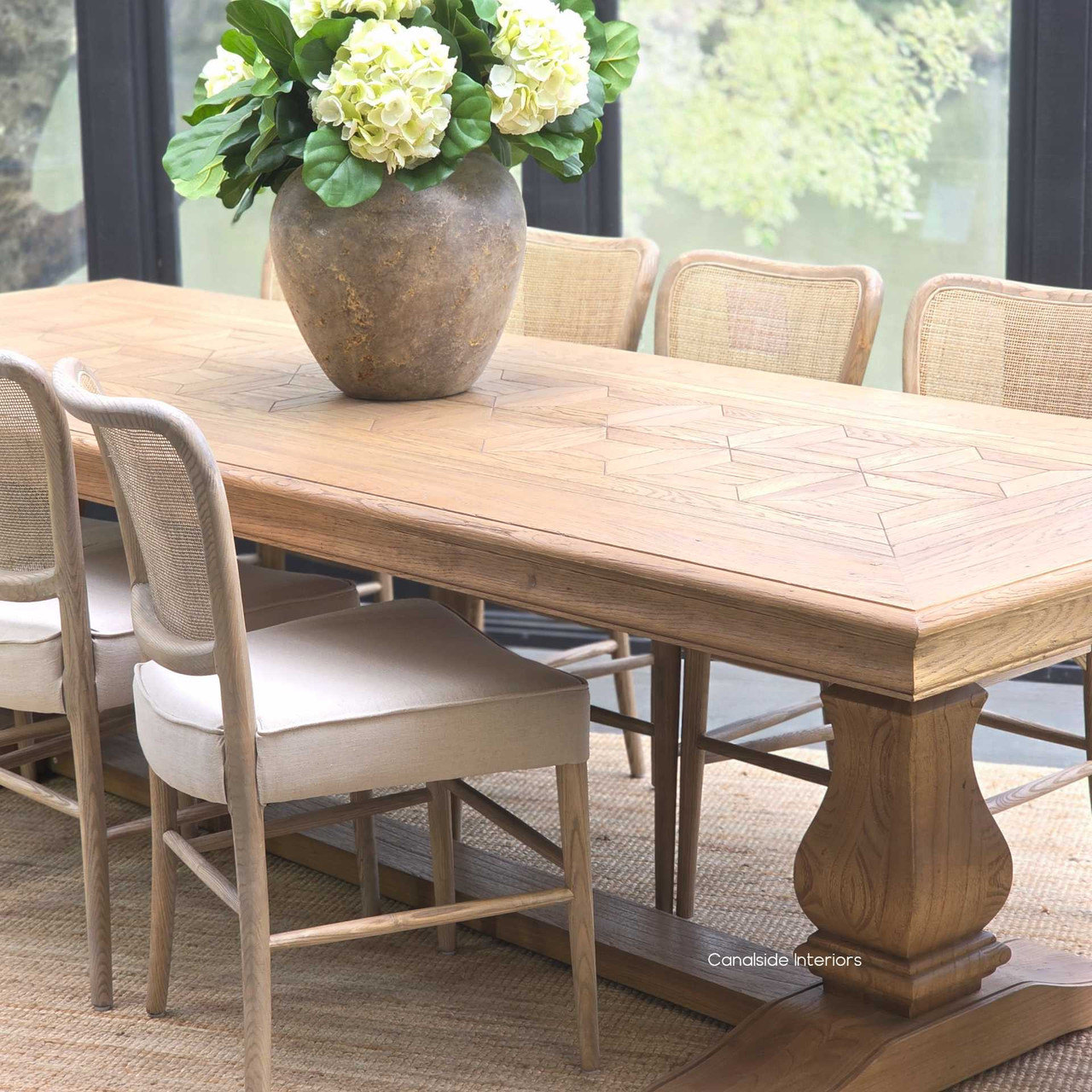 Front view of the Chesterton Oak Parquetry Dining Table 280cm showcasing its sculptural pedestal base.