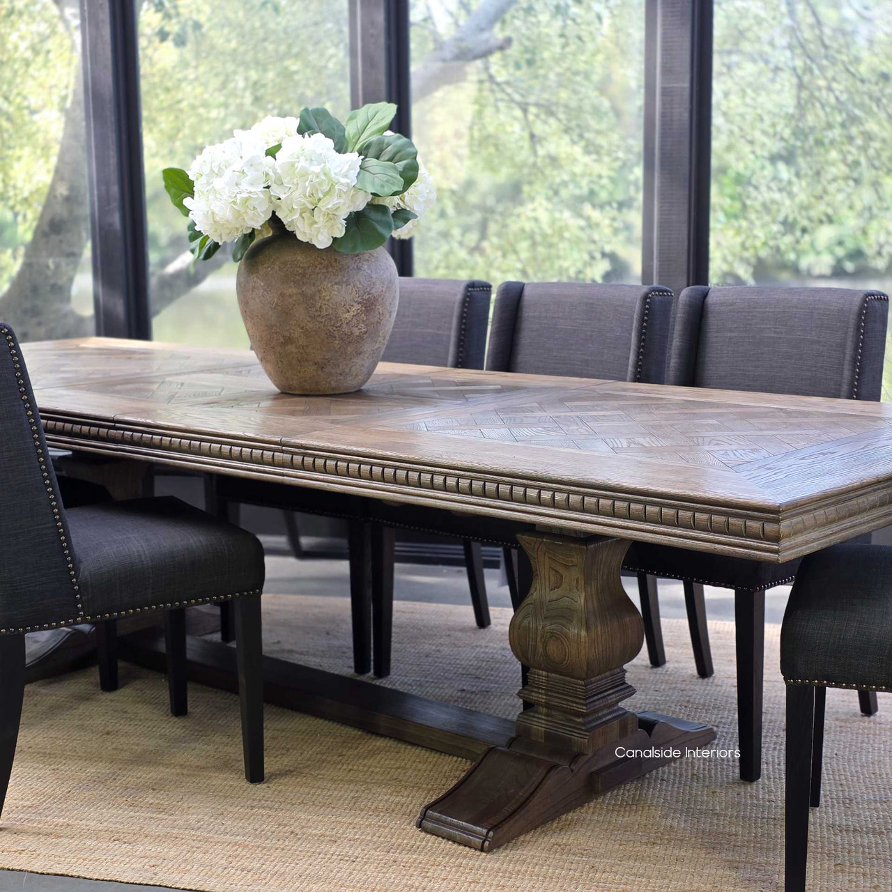 Luxurious dining space featuring extendable Cigar oak parquetry table and tufted upholstered chairs.