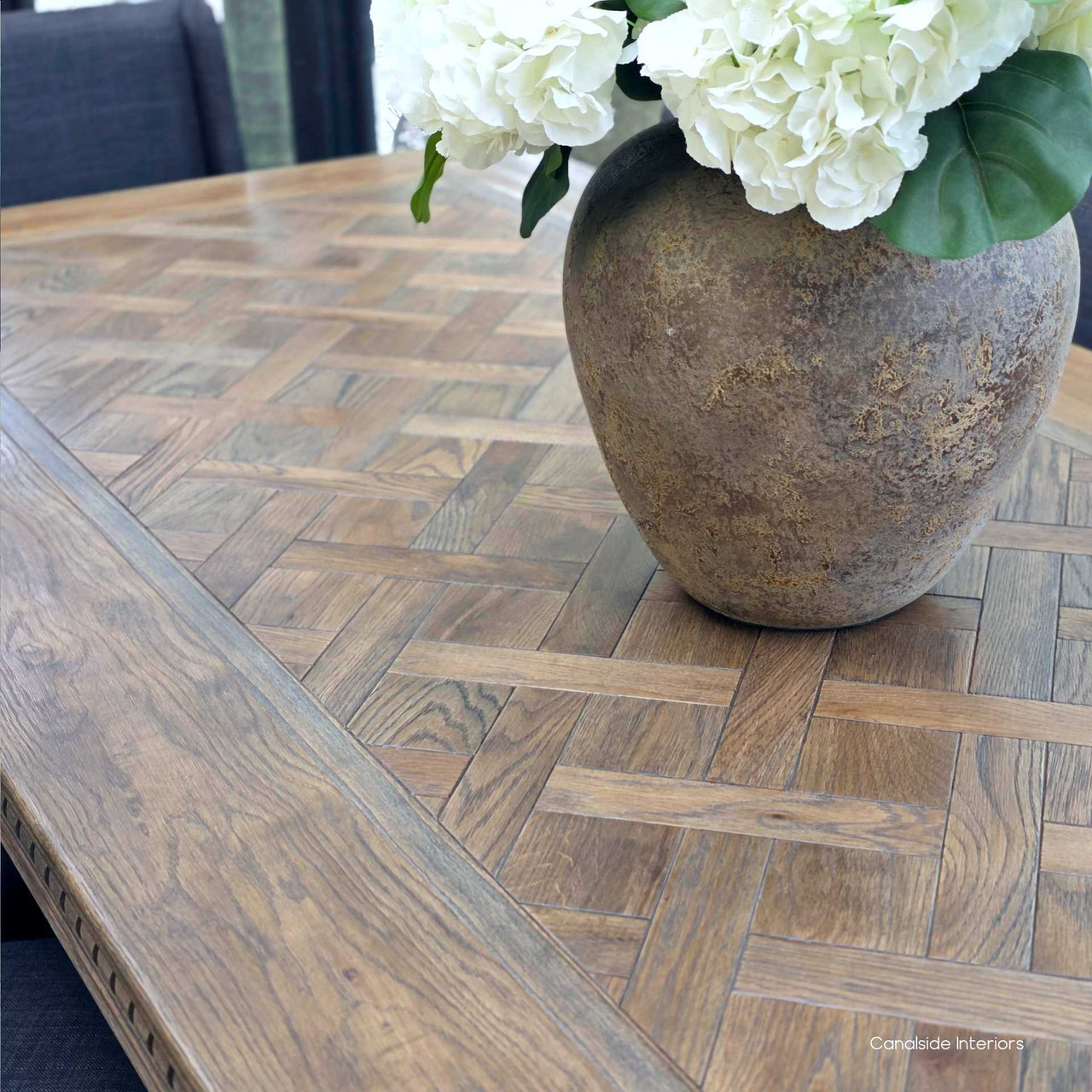 Close-up of timeless parquetry top on Berenson Cigar oak banquet table in a classic Hamptons dining room.