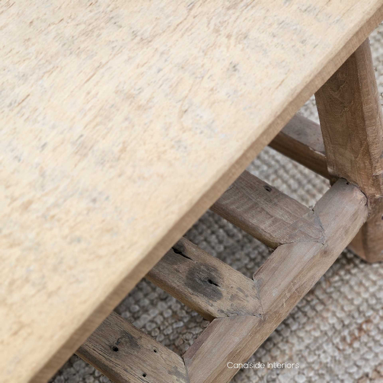 Low-angle shot of the Vintage Teak Bench, showcasing its sturdy structure, elegant proportions, and functional slatted lower shelf.