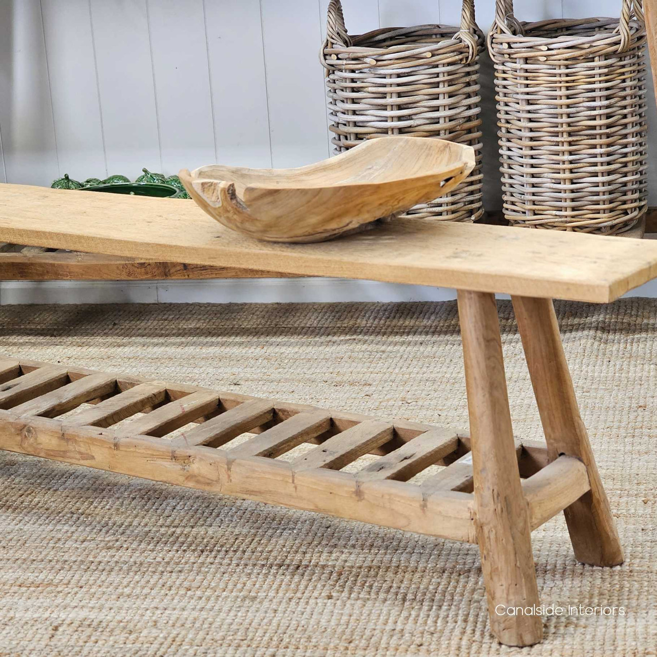 Side profile of the Vintage Teak Bench, highlighting its sleek design and open lower shelf for storage or styling.
