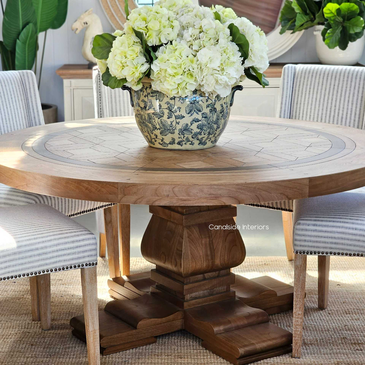 The robust pedestal of the Chambers Round Dining Table reflects a modern twist on classical architecture, perfect for a stately library or home office
