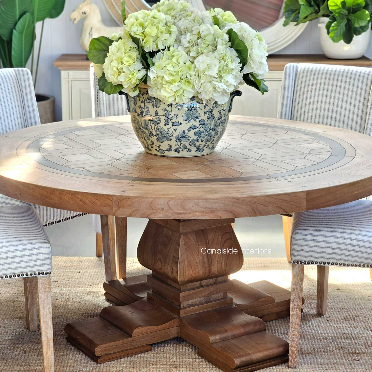 The Chambers Parquetry Round Dining Table, with its intricate top and solid pedestal base, brings timeless sophistication to your dining room - Canalside Interiors
