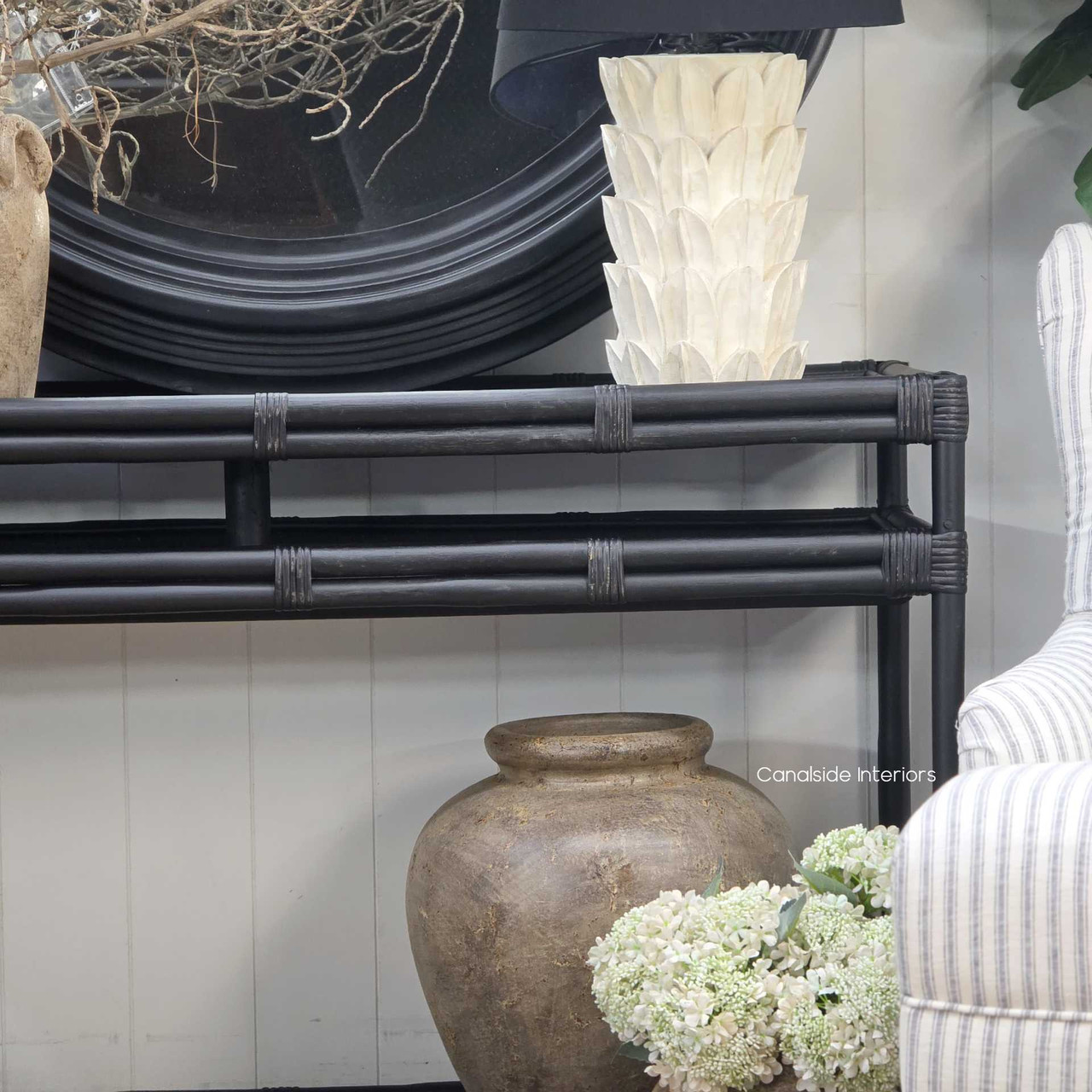 Finish detail highlighting tonal variations in the distressed black coating of the Raffles Rattan Console.