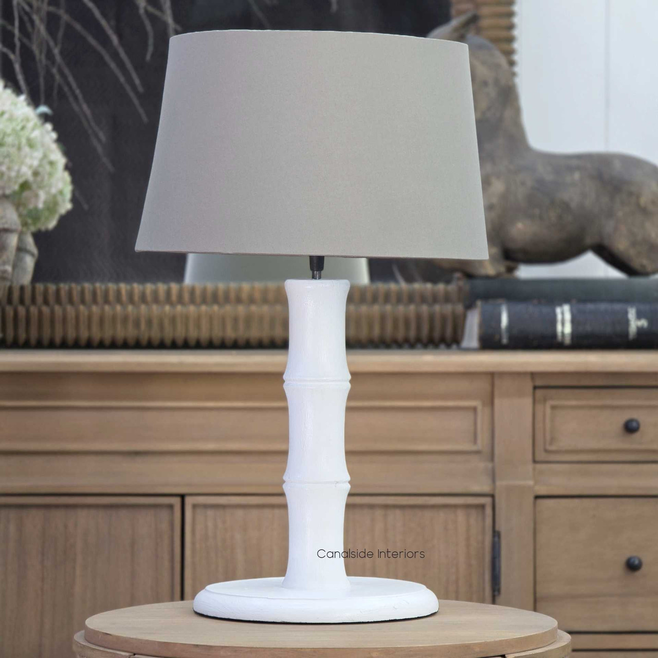 Distressed white bamboo table lamp styled in a coastal living room