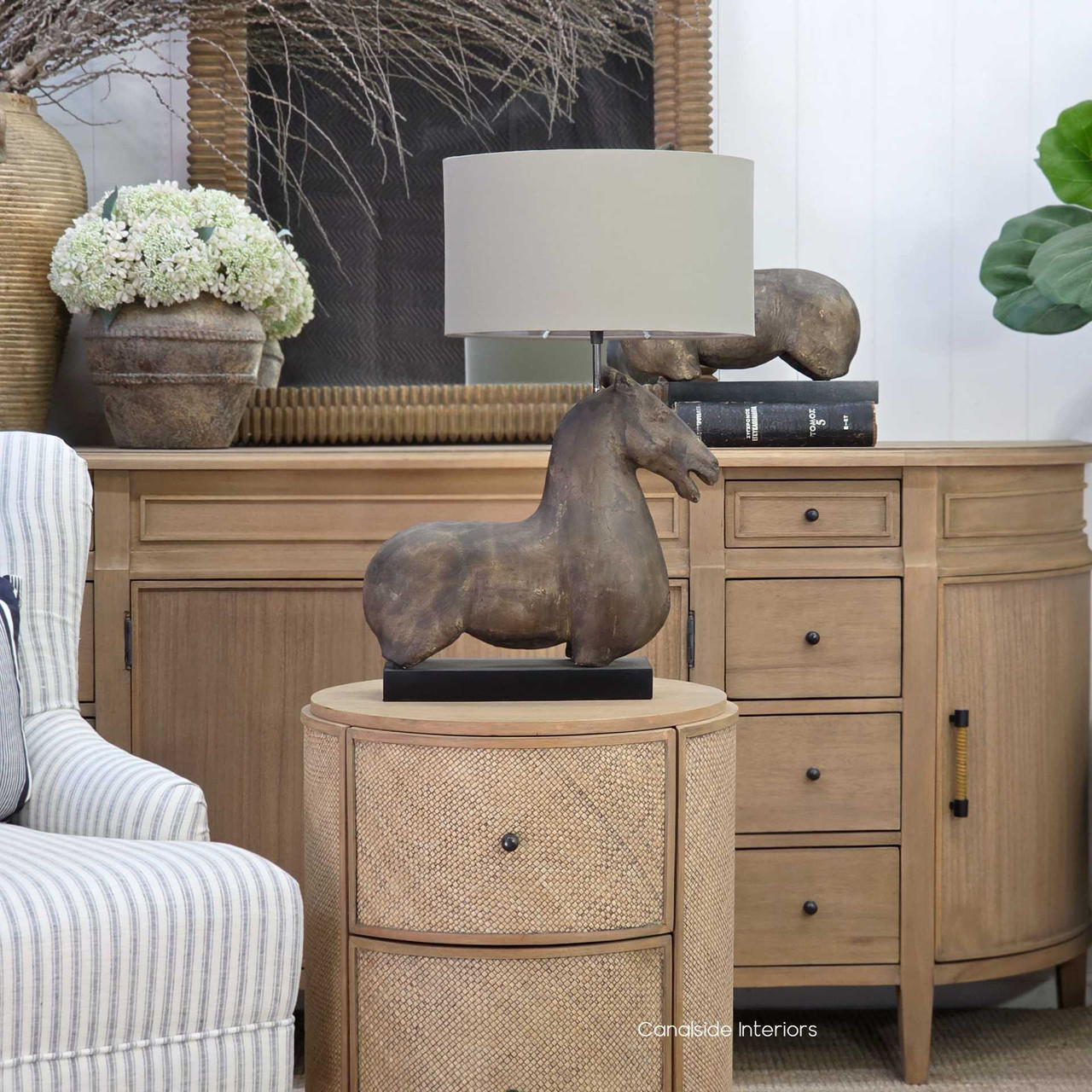 Single horse table lamp with taupe shade in coastal interior