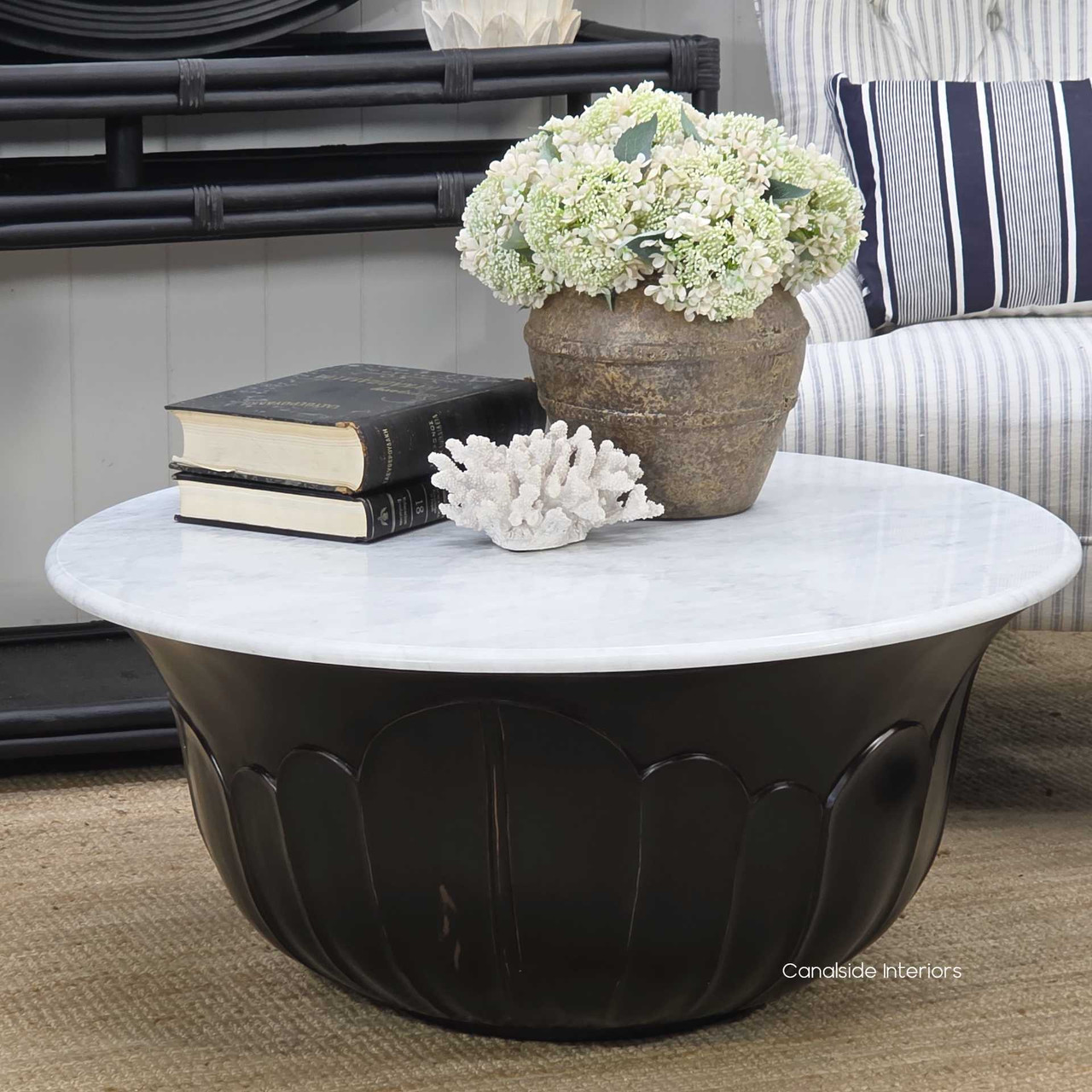 Low-angle shot that captures the curvature and shadows within the carved base, enhancing the table’s dimensional form and handcrafted appeal.