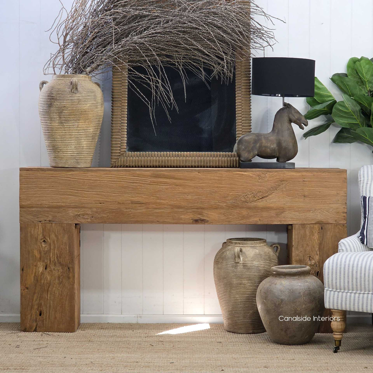 Reclaimed timber console table showcasing its solid block legs, natural timber top and beautifully weathered grain, styled with ceramics and sculptural décor.