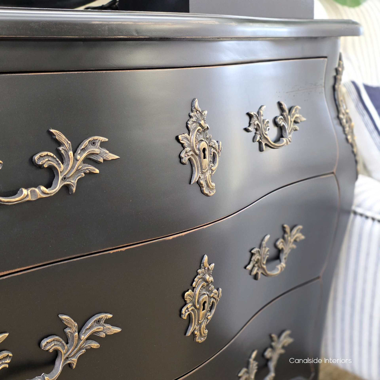 Three-quarter view styled with pottery and vintage accents, creating a relaxed, refined vignette.