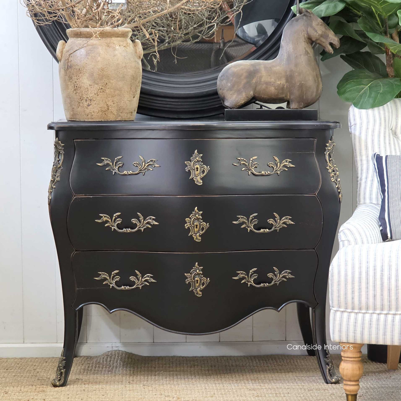 Front view of the Bretigny Commode Chest in distressed black, showcasing its bombe shape and ornate bronze hardware.