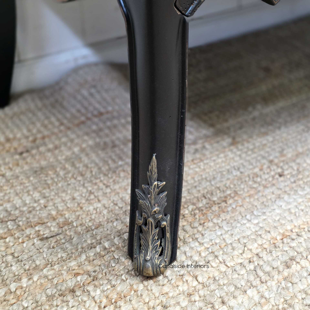 Side angle focusing on the flared leg design, with visible distressing along the base and aged brass hardware