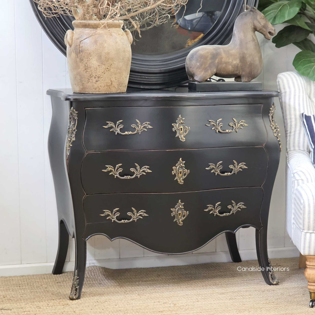 Side profile of the black commode, capturing the layered patina and traditional French detailing.