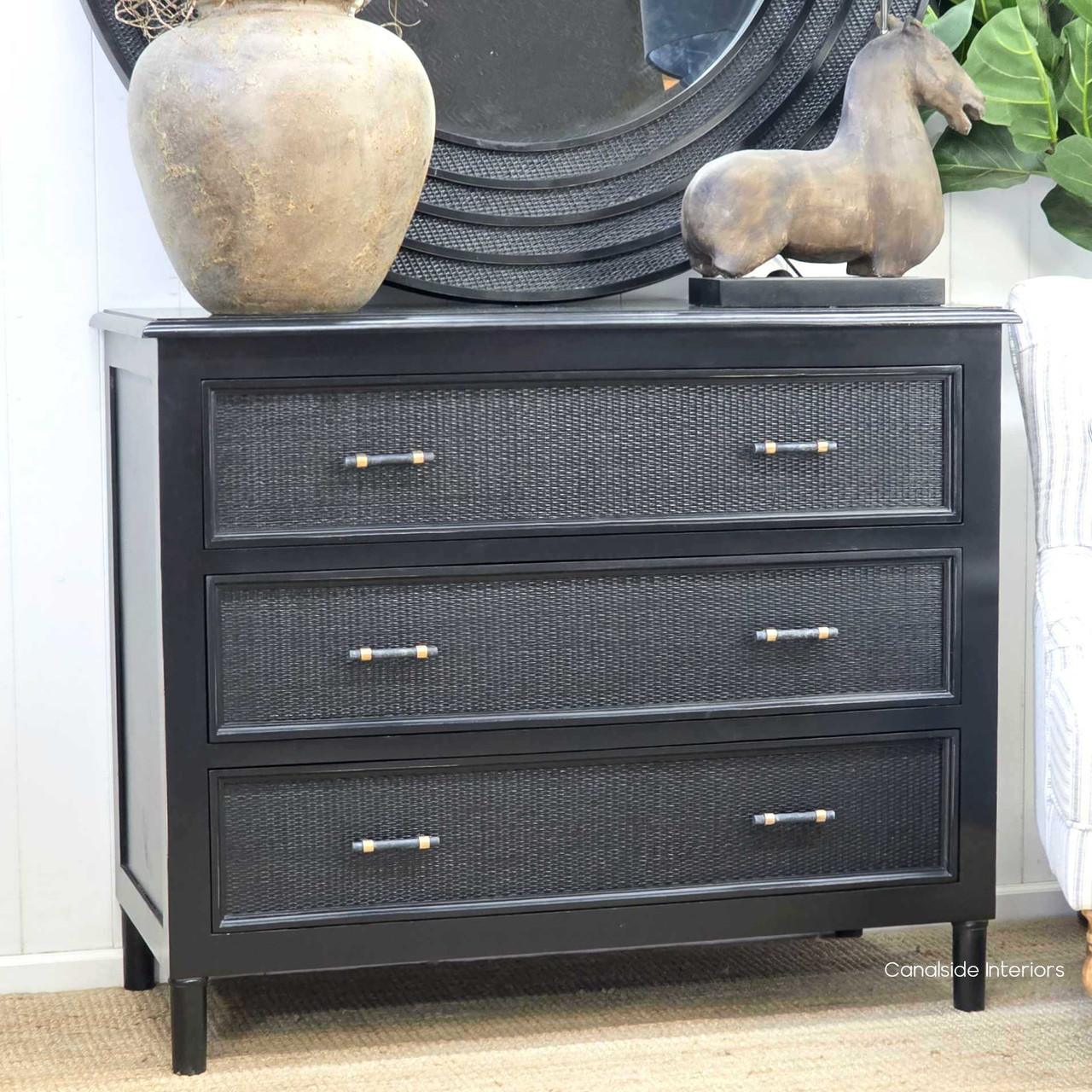 Black Brielle rattan 3 drawer chest styled with decorative objects in a modern hamptons home