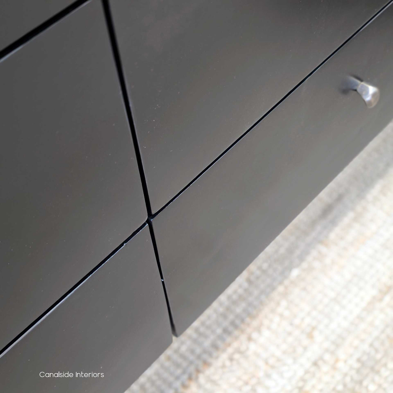 Drawer detail on the Creemore 6 Drawer Chest in Black, focusing on the simple metal knob and seamless drawer front design.