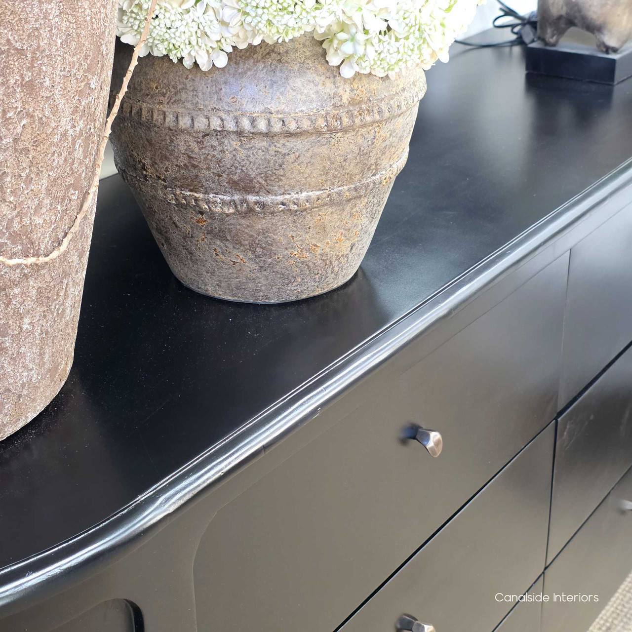 Styled top-surface view of the Creemore Chest in Black, featuring decorative accents to showcase the generous display space and soft rounded outline.