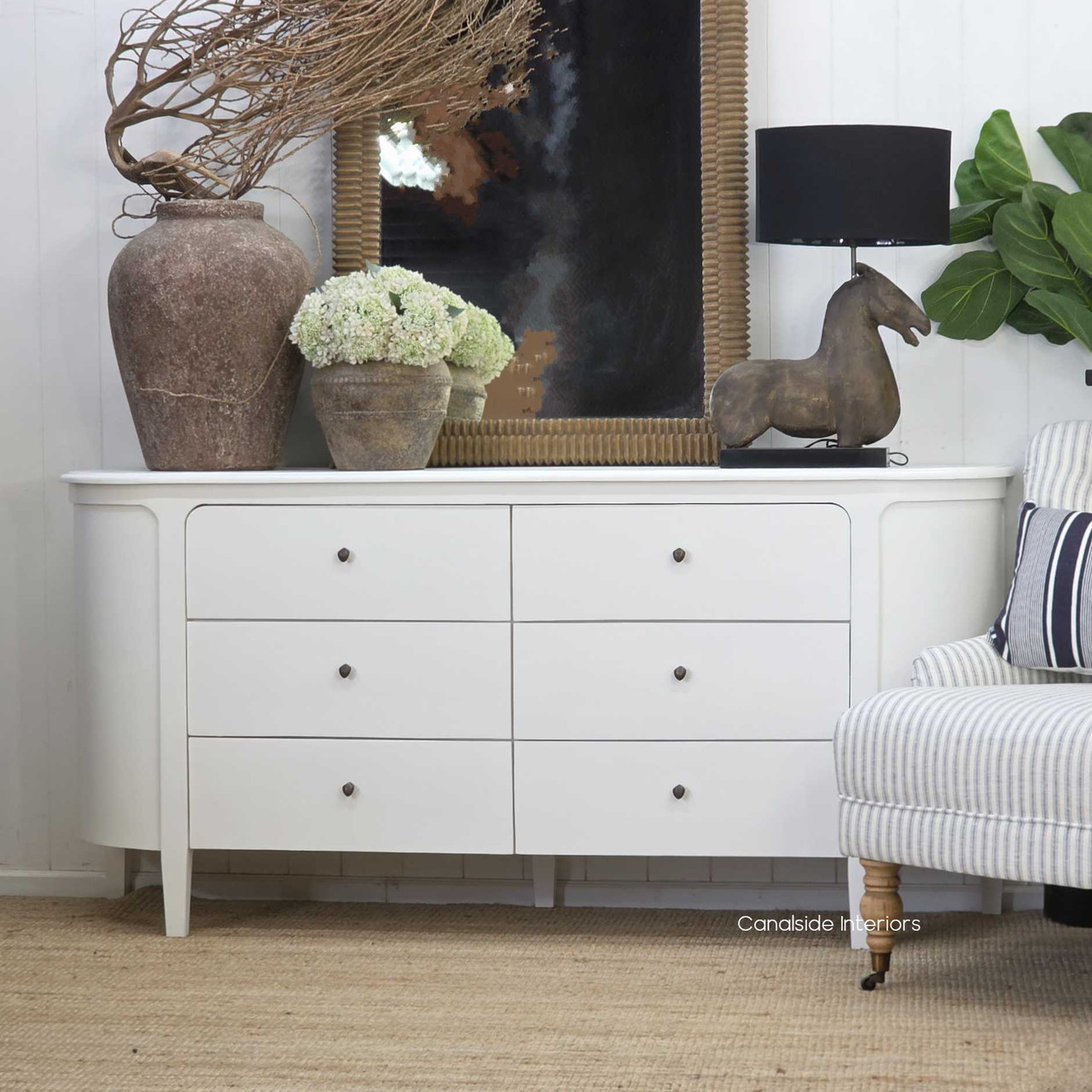 Angled view of the Creemore 6 Drawer Chest in White highlighting the sculpted body, curved corners and elegant tapered legs.