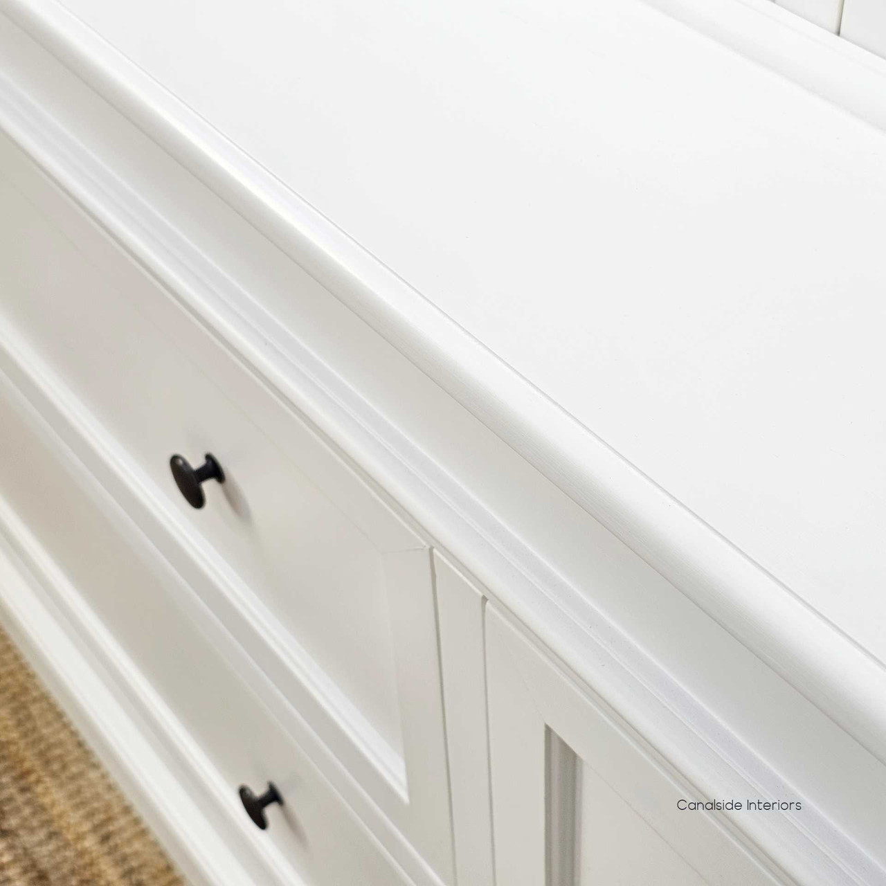 Close-up of drawer knob and surrounding panel for texture and finish quality.