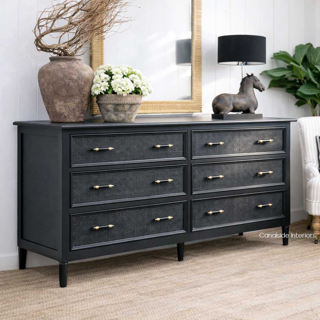 Angled view of the Black Brielle rattan 6 drawer chest styled with decorative objects, highlighting the contrast between dark painted timber and natural woven texture.
