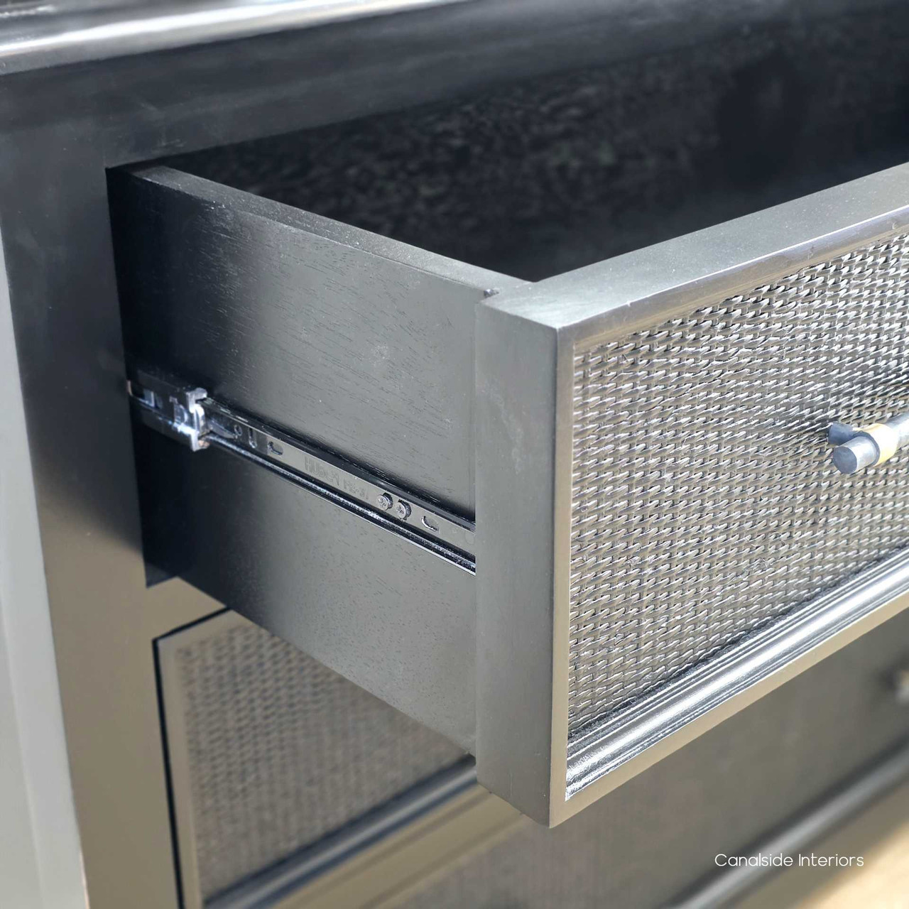 Open drawer view of the Brielle Rattan 6 Drawer Chest – Black showing the metal drawer runner, internal storage space and solid timber construction.