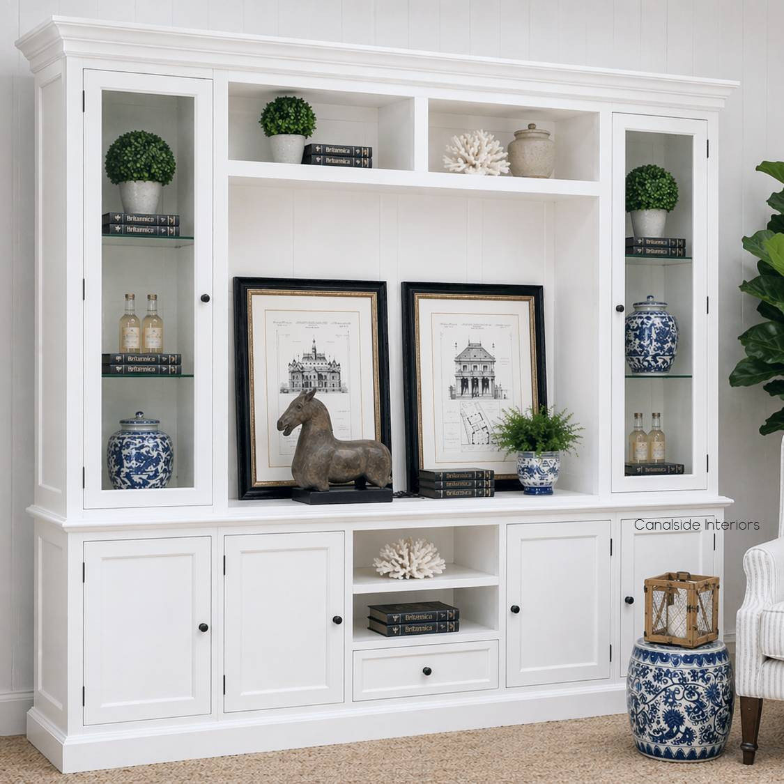 Angled perspective of the Casement TV Media Wall Unit with Glass Door Display in white featuring glazed display doors and six lower storage cupboards shown in a Hamptons interior setting.