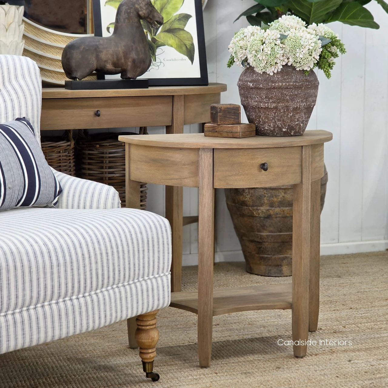Luna Demilune Side Table angled view highlighting its graceful curved tabletop and natural timber finish.