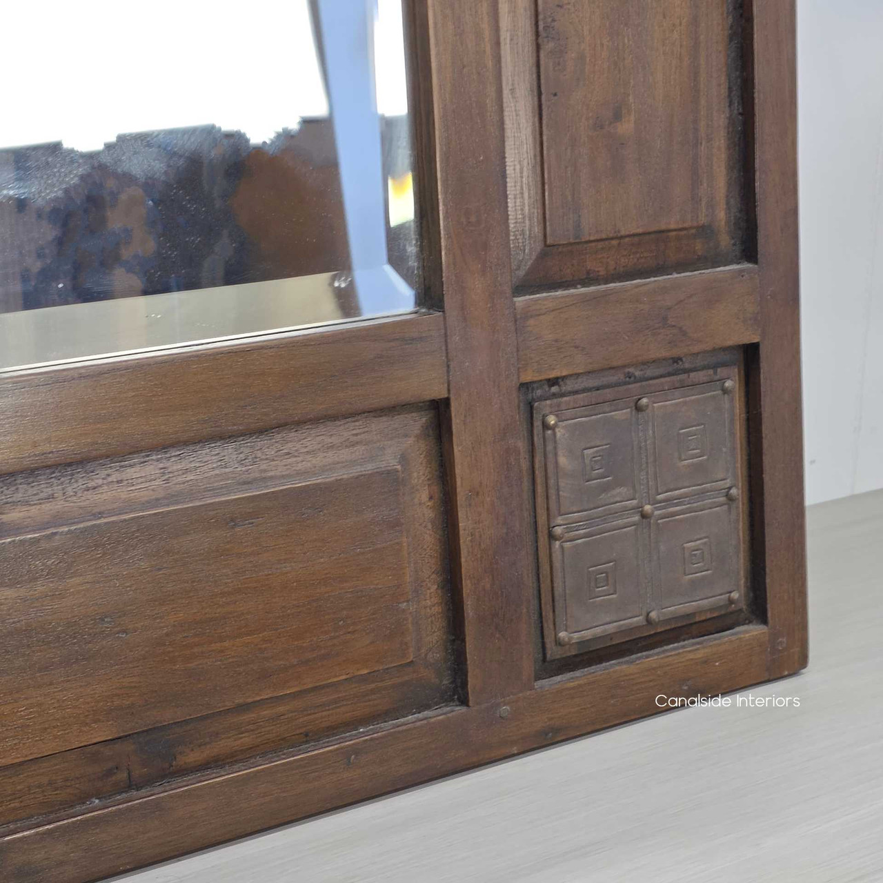 Detailed view of the carved square design embedded into the corner of the frame.