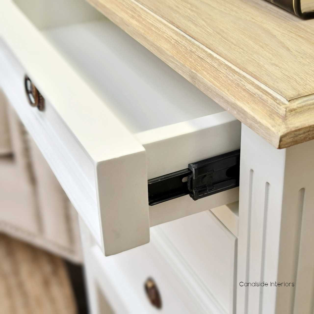 Angled view of the bedside table, displaying its smooth metal runner drawers, combining functionality with style.
