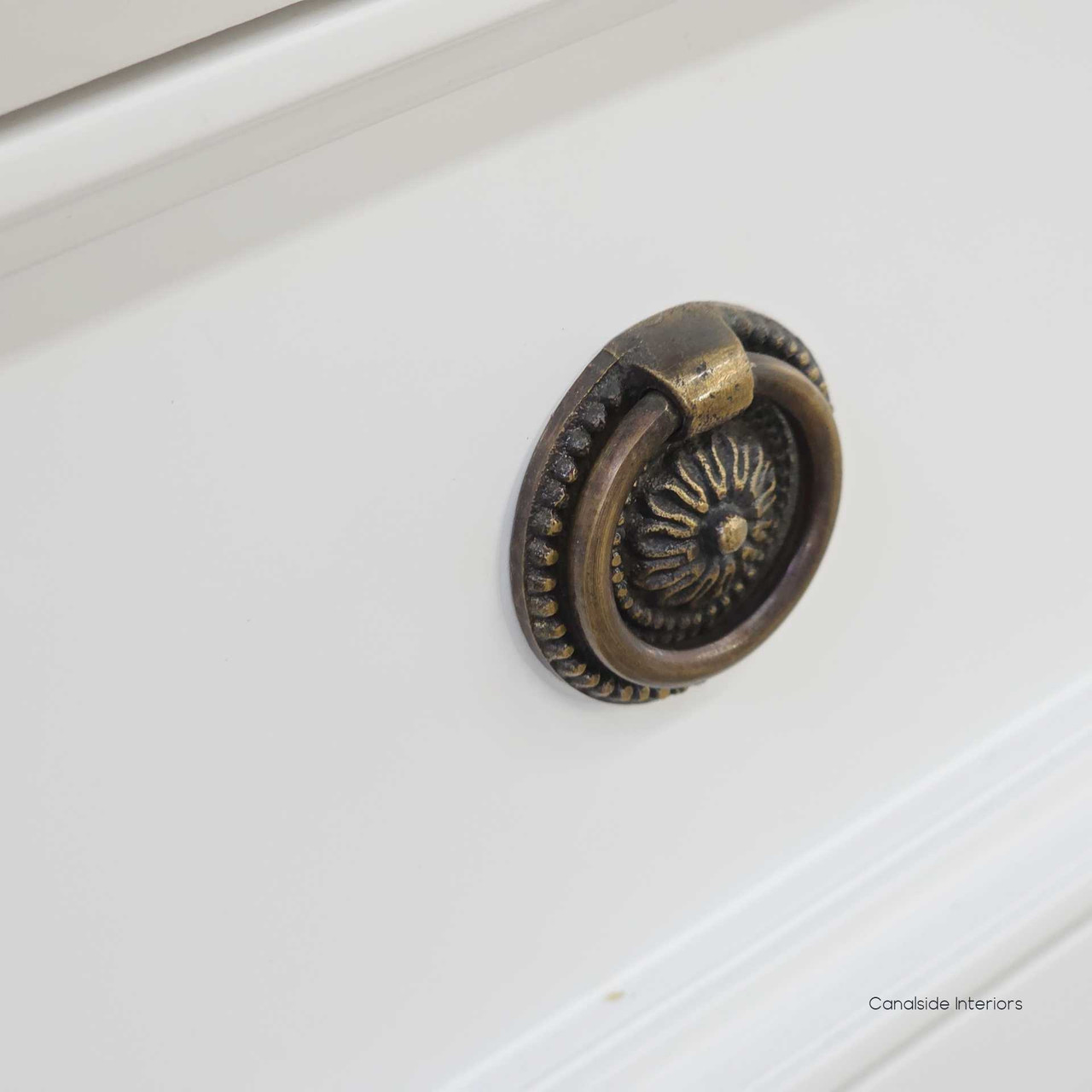 Tight hardware detail showing the antique-style brass ring pull with decorative beading.